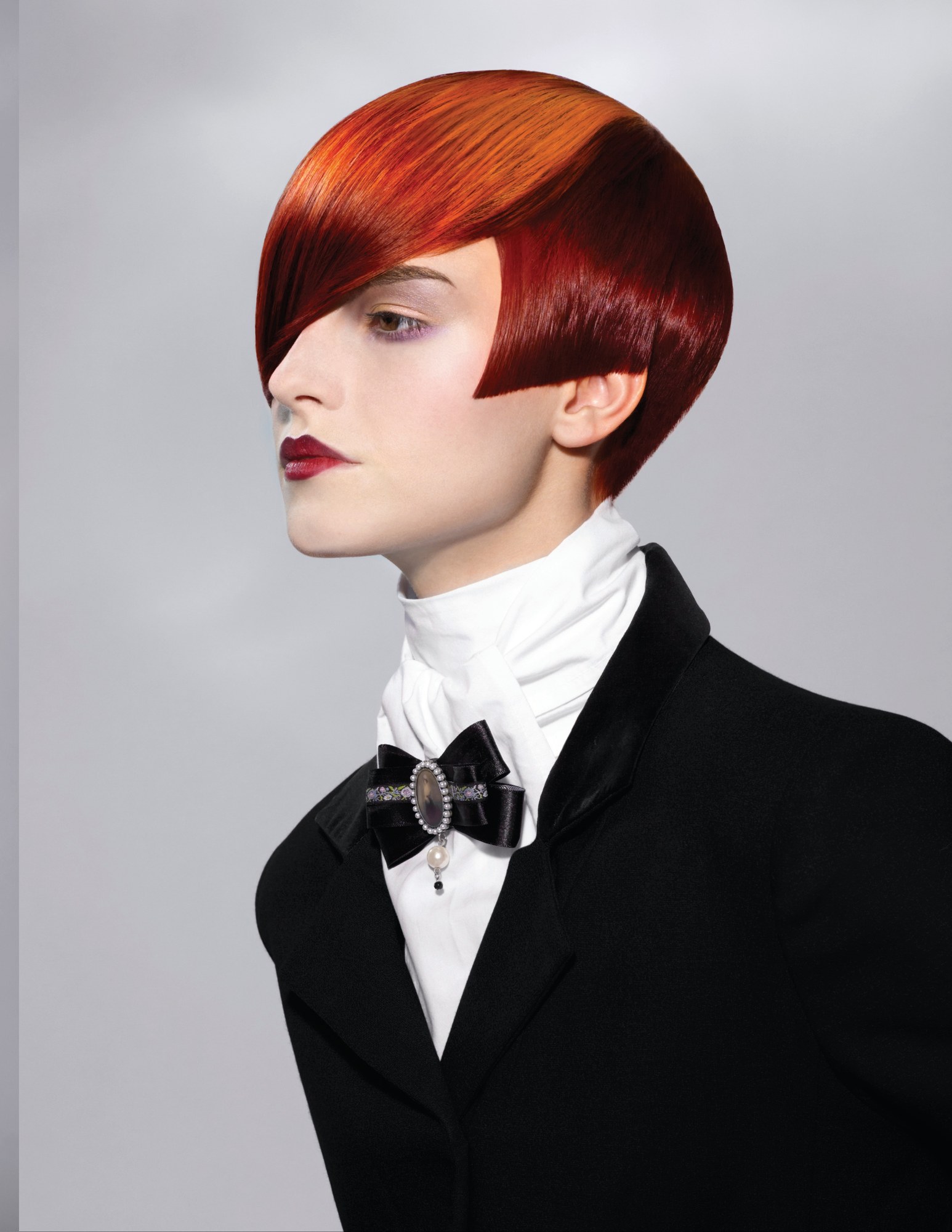 Deep red bowl cut with a long angled fringe, black bow tie – Gilded Youth Collection, Sassoon 2008